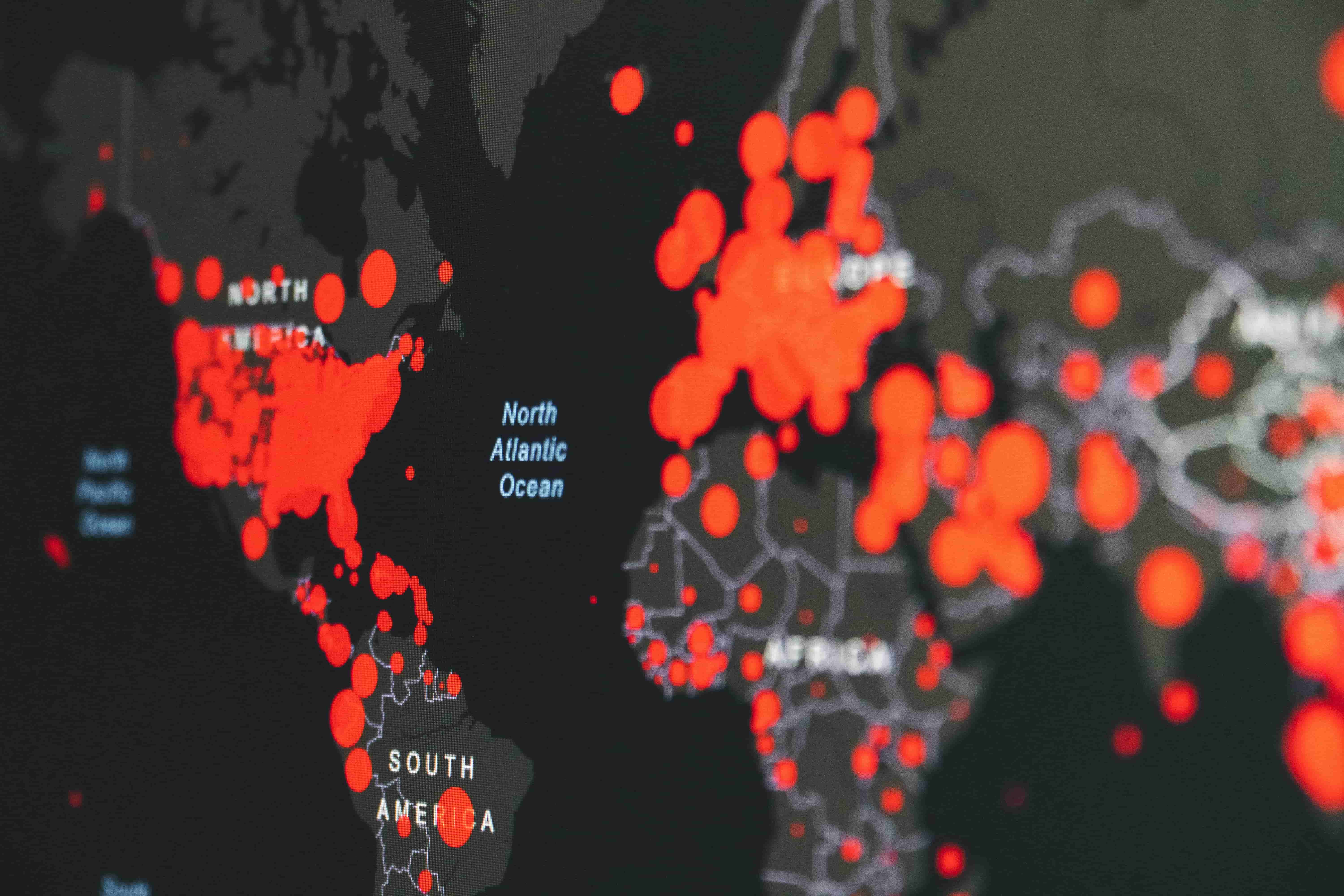 A world map with red dots on top of countries representing their proportion of pandemic cases